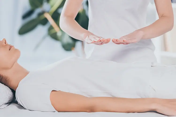 A calm, softly lit reiki treatment room with a treatment table set up for a session