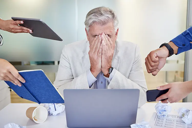 An employee looking stressed at a desk in an Irish office
