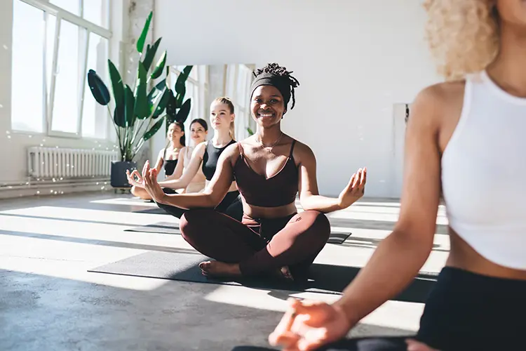 A beginner setting up their mat in a yoga studio before class starts