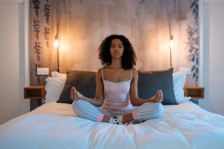 A person lying down comfortably with eyes closed during a guided yoga nidra session
